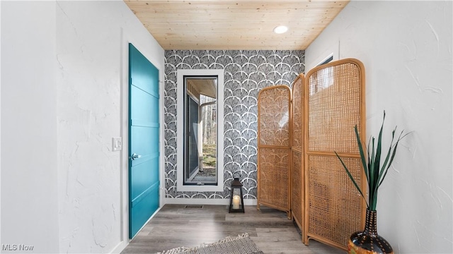interior space with wooden ceiling, baseboards, wallpapered walls, and wood finished floors