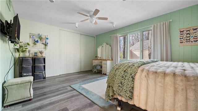 bedroom featuring a textured ceiling, ceiling fan, and wood finished floors