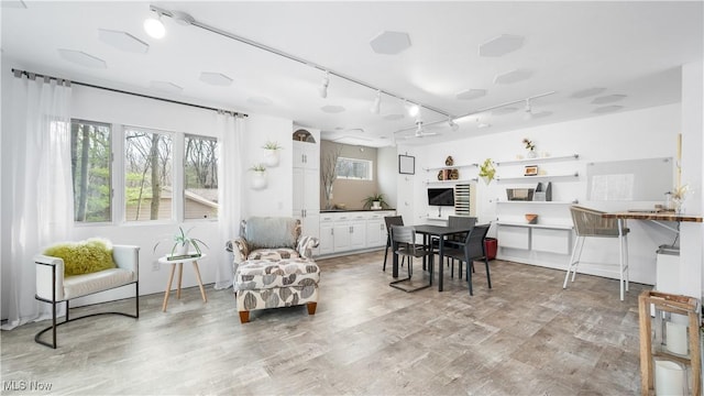 dining space featuring track lighting and light wood finished floors