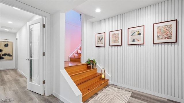 stairs with baseboards, recessed lighting, and wood finished floors