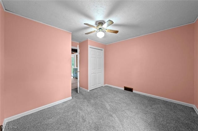 unfurnished bedroom featuring baseboards, carpet flooring, a textured ceiling, and visible vents