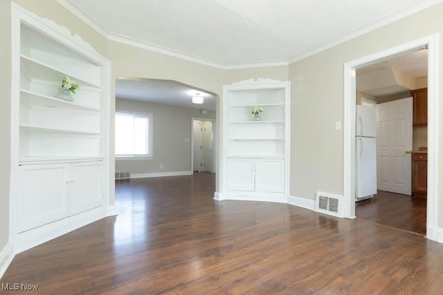 empty room featuring arched walkways, baseboards, visible vents, and ornamental molding