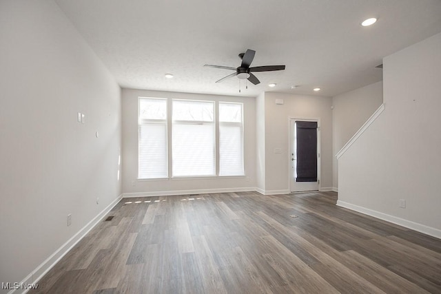 unfurnished living room with baseboards, ceiling fan, recessed lighting, and dark wood-type flooring