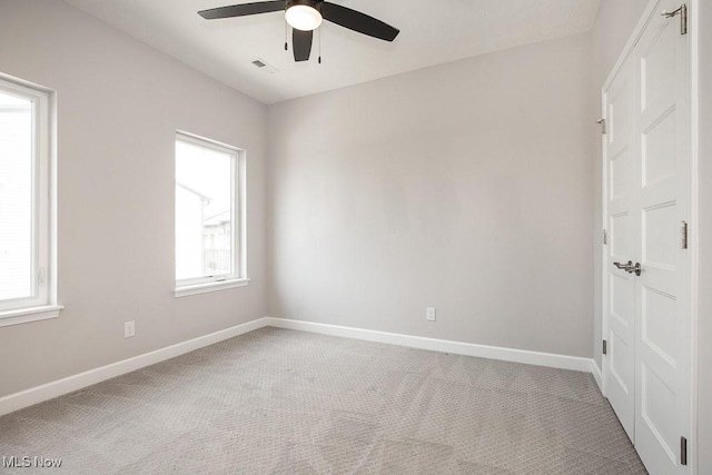 spare room featuring a ceiling fan, baseboards, visible vents, and carpet