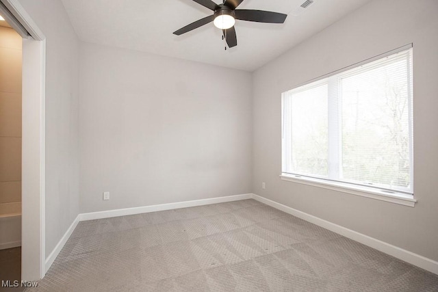 carpeted spare room with baseboards and ceiling fan