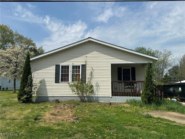 view of property exterior featuring a lawn and covered porch