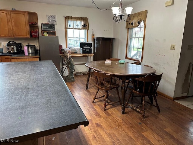 dining room with baseboards, an inviting chandelier, and wood finished floors