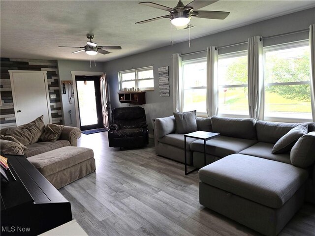 living room featuring visible vents, a ceiling fan, and wood finished floors