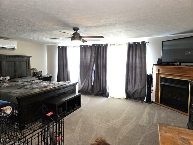 bedroom featuring a fireplace, light colored carpet, a textured ceiling, a wall unit AC, and a ceiling fan