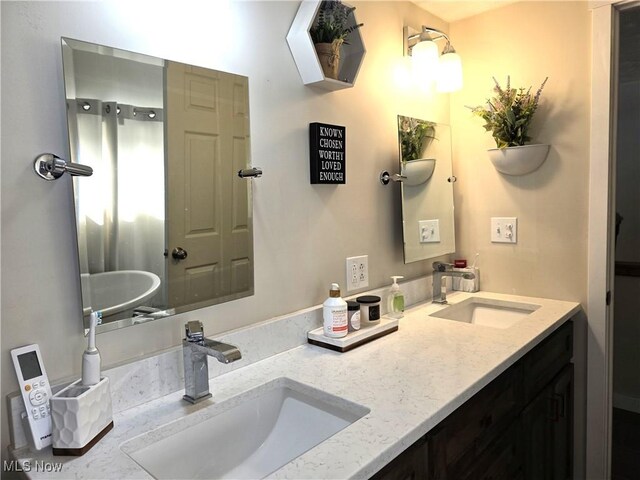 full bathroom featuring double vanity and a sink