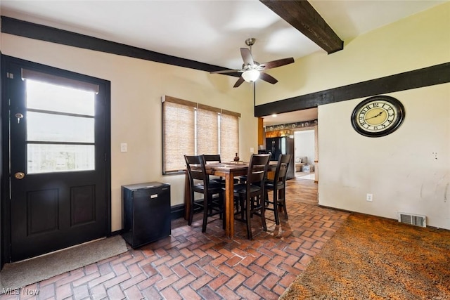 dining area with beam ceiling, brick floor, a ceiling fan, baseboards, and visible vents