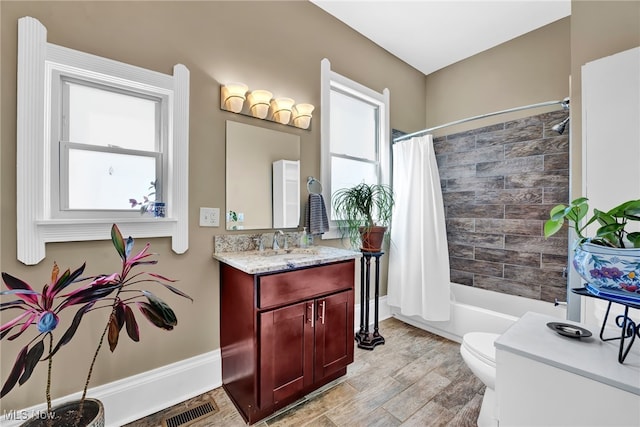 full bath with visible vents, shower / bath combo with shower curtain, a wealth of natural light, and toilet