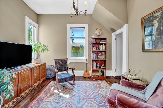 sitting room with baseboards, dark wood-style flooring, a chandelier, and a healthy amount of sunlight