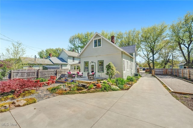 back of house featuring fence, a chimney, and a wooden deck