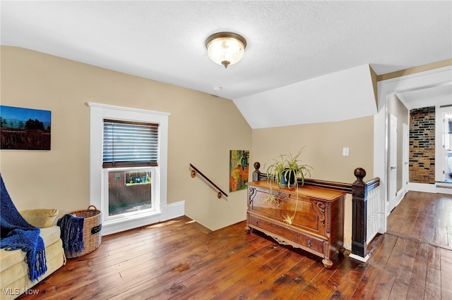 sitting room with vaulted ceiling and hardwood / wood-style floors