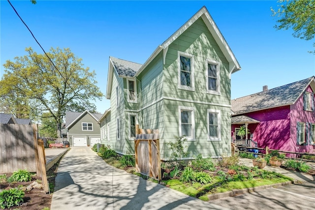 view of front of house featuring concrete driveway, fence, and a garage