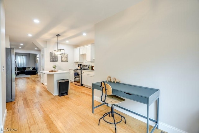 kitchen with recessed lighting, light countertops, white cabinetry, a center island, and appliances with stainless steel finishes
