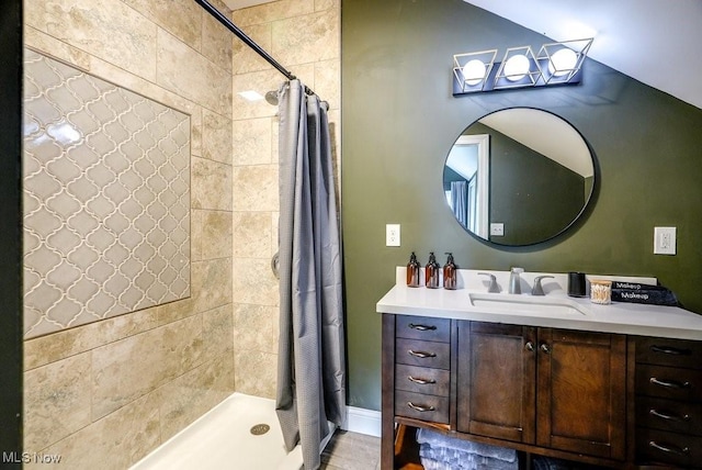 full bathroom featuring vanity, baseboards, and a tile shower
