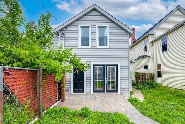 rear view of property featuring a patio area and fence