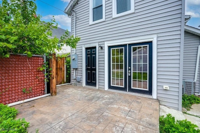 view of patio / terrace with central AC, fence, and french doors