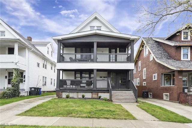 view of front of house with a porch, a front lawn, and a balcony