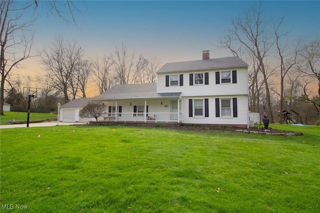 view of front facade featuring a porch, a front yard, driveway, and a chimney