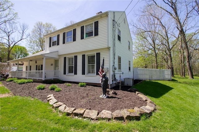 view of front of property featuring central air condition unit, fence, a porch, and a front yard