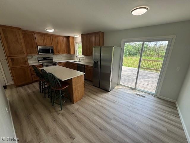 6720 Prior Rd, Nashport, OH 43830 - kitchen featuring stainless steel appliances, decorative backsplash, a sink, and light wood finished floors