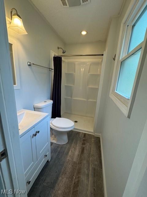 6720 Prior Rd, Nashport, OH 43830 - full bathroom featuring visible vents, a stall shower, wood finished floors, vanity, and toilet