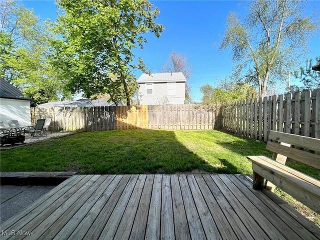 wooden terrace featuring a lawn and a fenced backyard