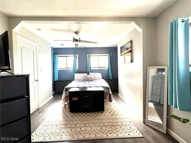 bedroom featuring a ceiling fan, baseboards, and wood finished floors