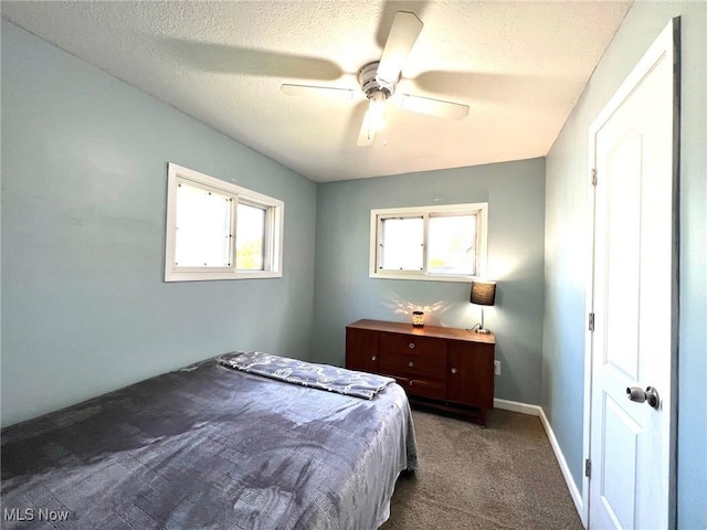 carpeted bedroom featuring a ceiling fan, a textured ceiling, and baseboards