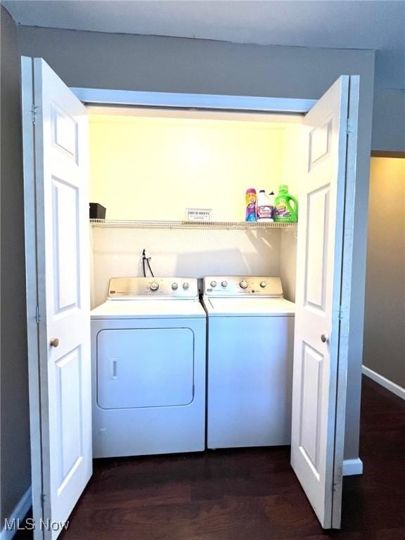 clothes washing area with laundry area, dark wood finished floors, and washing machine and clothes dryer
