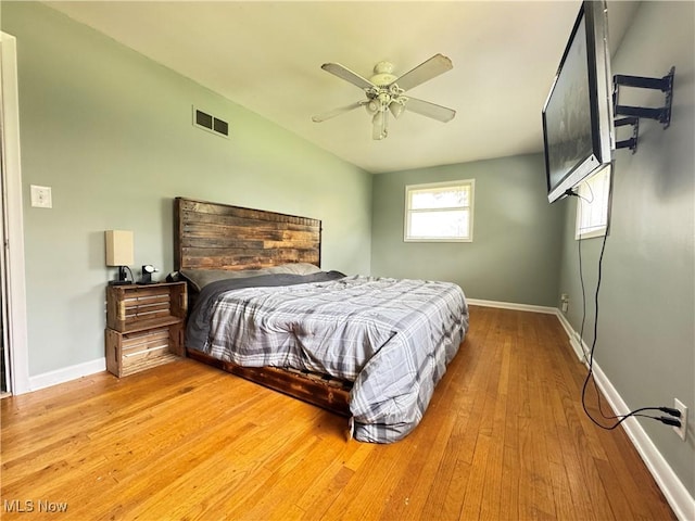 bedroom with baseboards, visible vents, ceiling fan, and hardwood / wood-style flooring