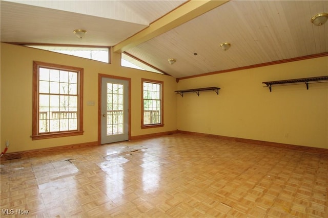 interior space with baseboards and lofted ceiling with beams