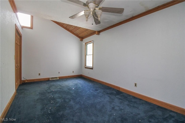 carpeted empty room featuring crown molding, visible vents, baseboards, ceiling fan, and vaulted ceiling