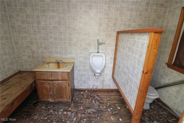 half bath featuring toilet, tile walls, and vanity