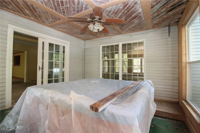bedroom with ceiling fan and wooden walls