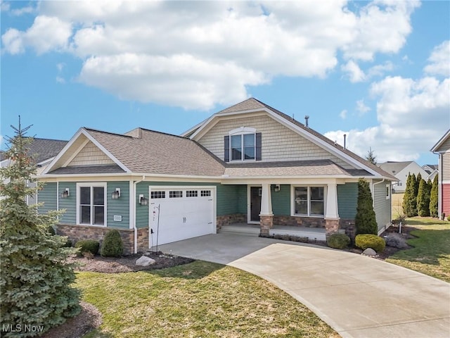 craftsman inspired home with driveway, a front lawn, an attached garage, a shingled roof, and stone siding