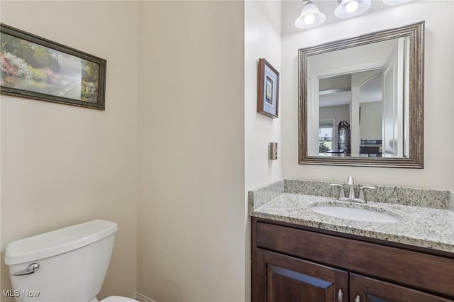 half bath featuring toilet and vanity
