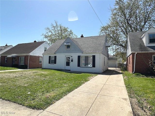 view of front of home featuring driveway, a front lawn, and brick siding