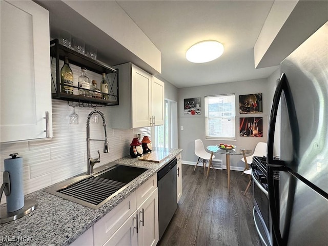 kitchen with white cabinets, open shelves, a sink, dishwasher, and freestanding refrigerator