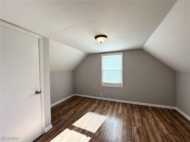 bonus room featuring baseboards, vaulted ceiling, and wood finished floors