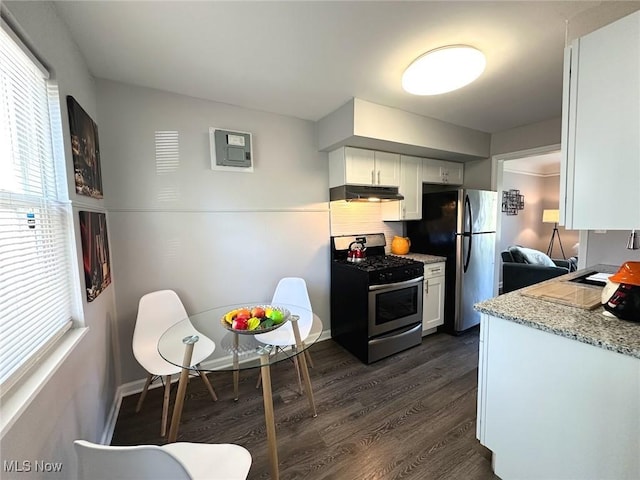 kitchen featuring appliances with stainless steel finishes, white cabinetry, a wealth of natural light, dark wood-type flooring, and under cabinet range hood