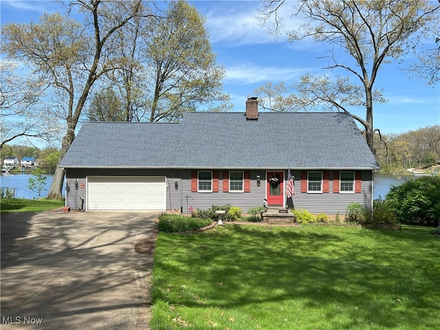 view of front of home with an attached garage, a front lawn, driveway, and a chimney