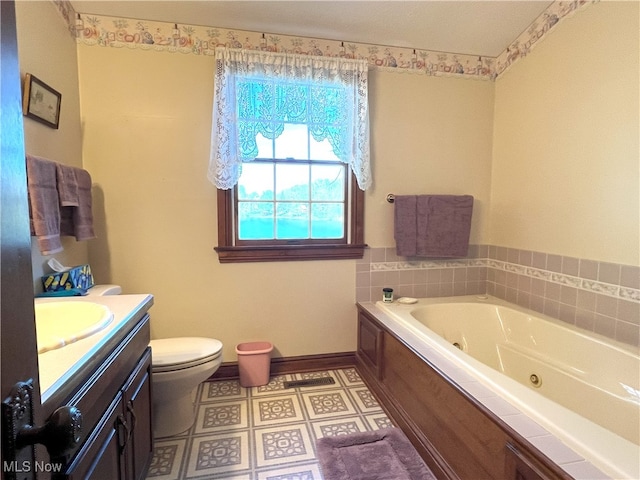bathroom with vanity, baseboards, a whirlpool tub, and toilet