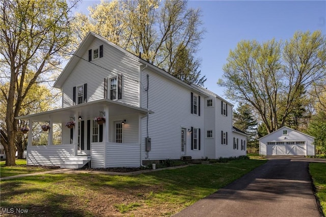 view of home's exterior with a detached garage, an outbuilding, and a yard