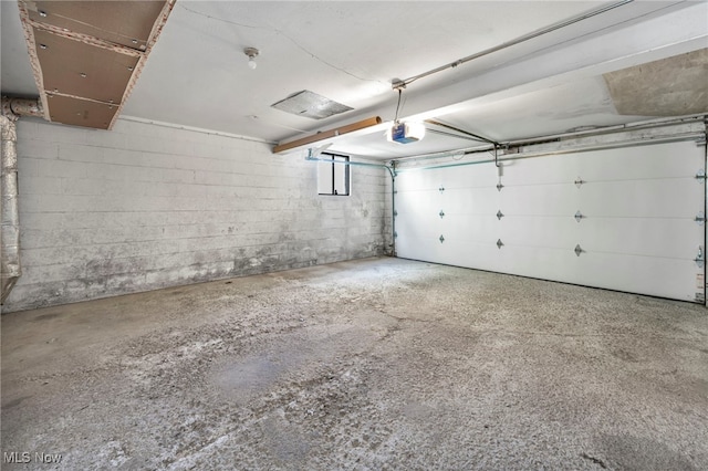 garage with concrete block wall and a garage door opener