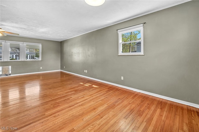 unfurnished room with wood-type flooring, a ceiling fan, and baseboards