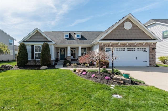 craftsman-style home featuring stone siding, a garage, a porch, a front yard, and concrete driveway